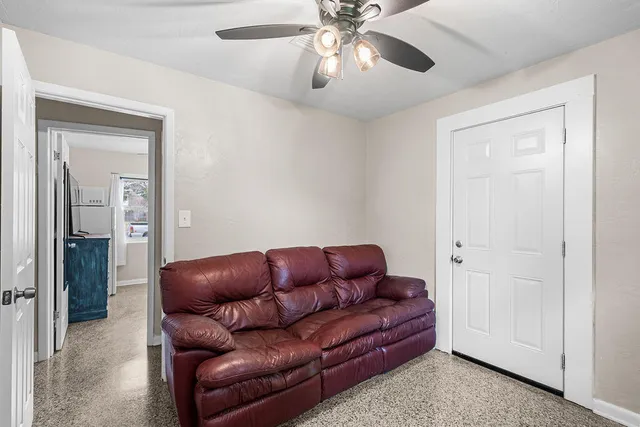 a living room with furniture and a ceiling fan