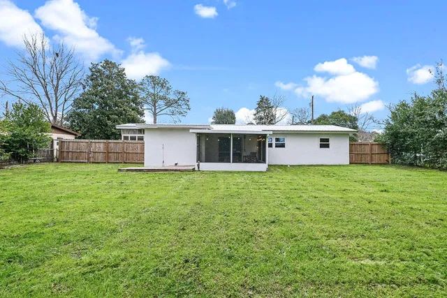 a view of a house with a yard and trees