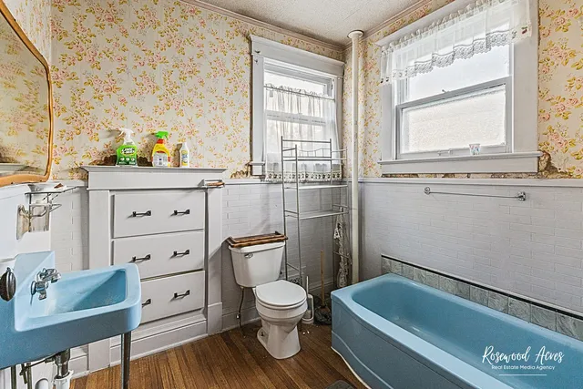 a bathroom with a toilet sink and mirror