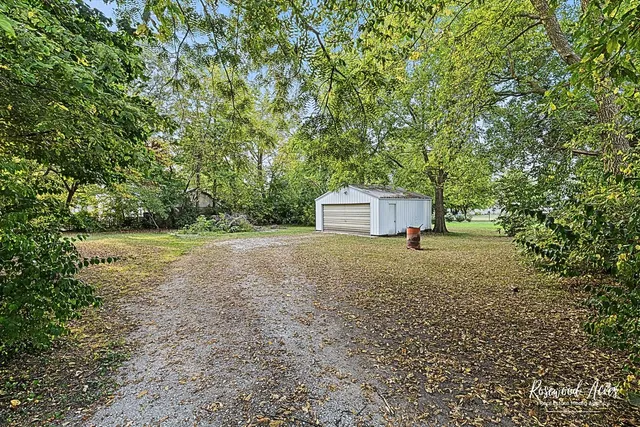 a backyard of a house with a yard and tree