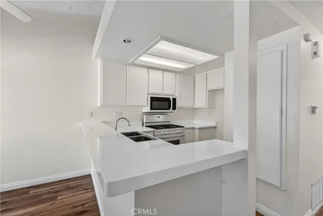 a kitchen with stainless steel appliances a stove microwave and sink