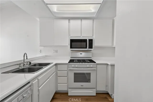 a kitchen with a sink stove top oven and cabinets