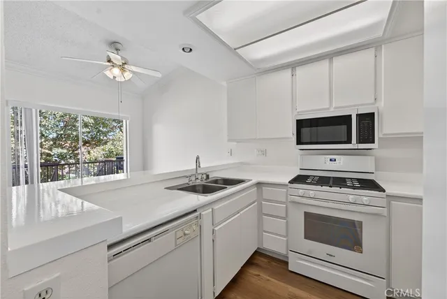 a kitchen with a sink stove top oven and microwave