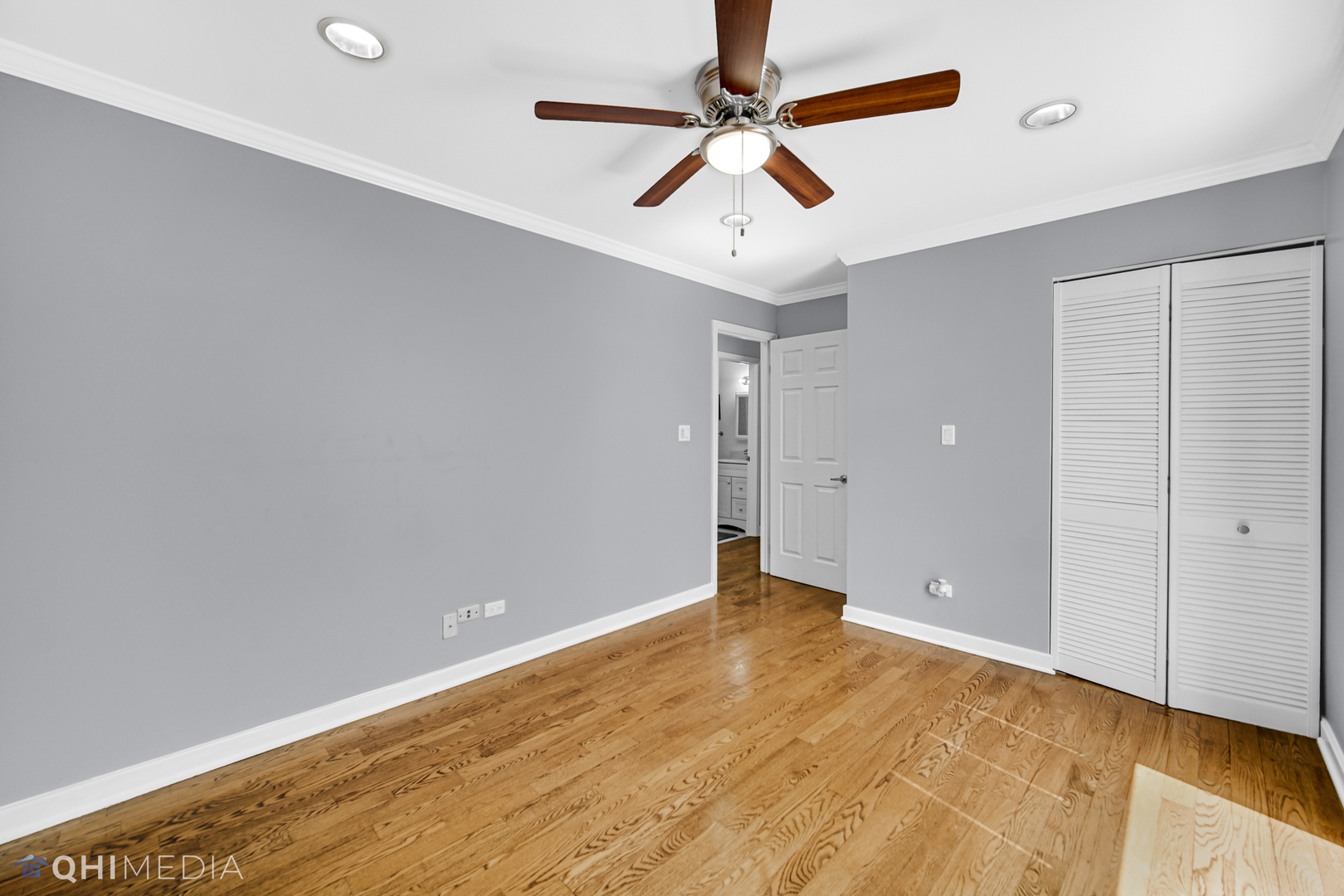 232 Inverrary Lane, Unit 232 Deerfield, IL 60015 - Photo 18 of 27 an empty room with a ceiling fan and wooden floor