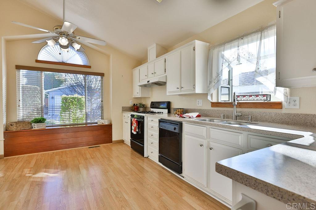 15935 Spring Oaks Road, Unit SPC 169 El Cajon, CA 92021 - Photo 2 of 24 a kitchen with stainless steel appliances granite countertop a stove a sink dishwasher and a refrigerator with wooden floor