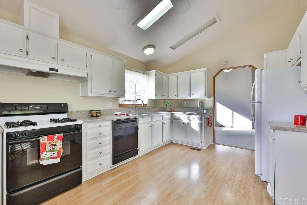15935 Spring Oaks Road, Unit SPC 169 El Cajon, CA 92021 - Photo 3 of 24 a kitchen with granite countertop a stove top oven and cabinets