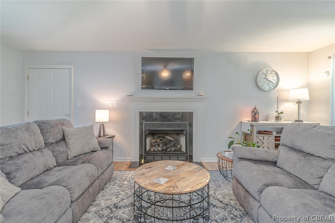 11654 Courthouse Road Lancaster, VA 22503 - Photo 6 of 35 a living room with furniture a fireplace and a flat screen tv