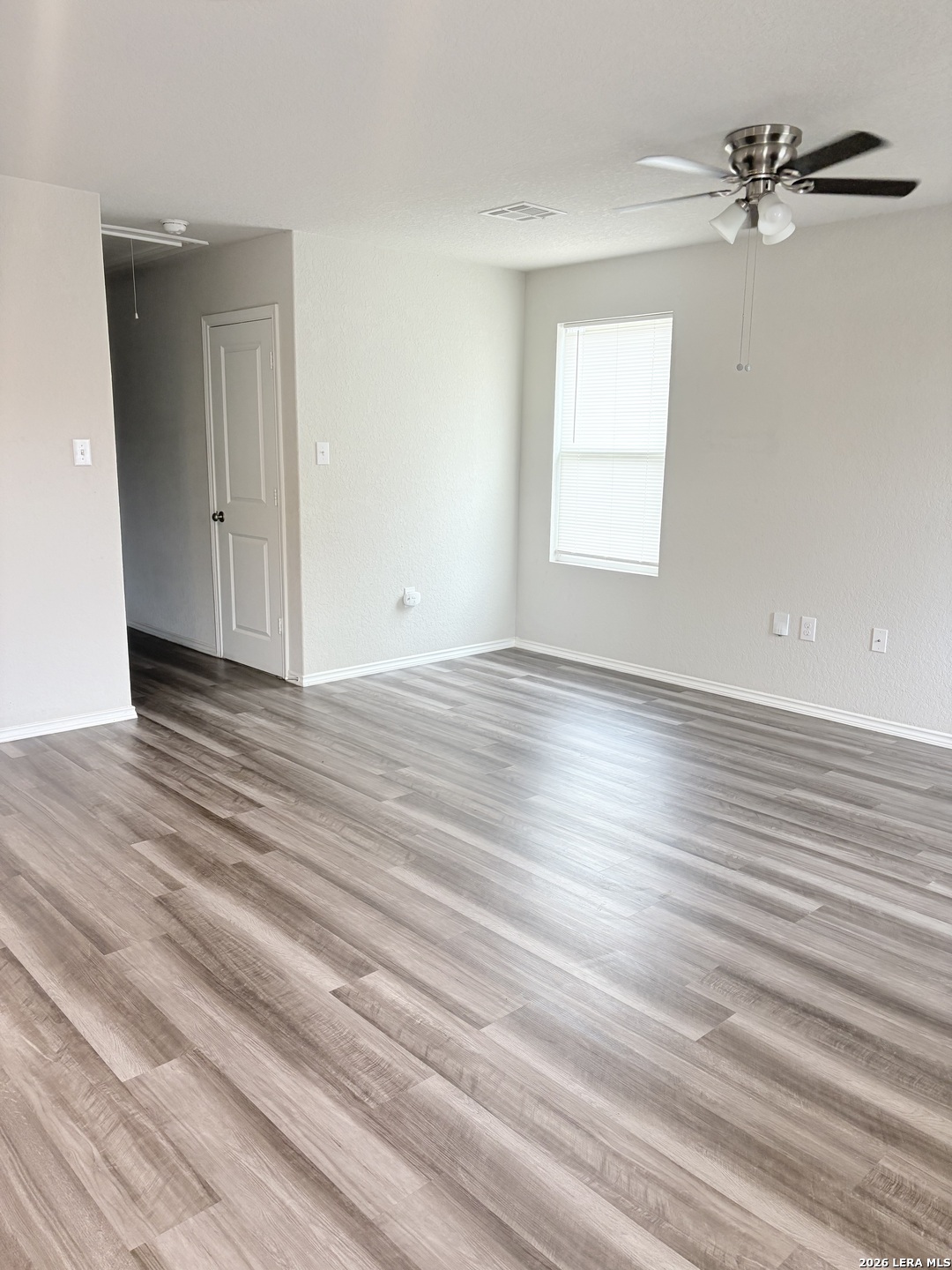 7022 Sunspot Converse, TX 78109 - Photo 6 of 18 a view of an empty room with wooden floor and a window