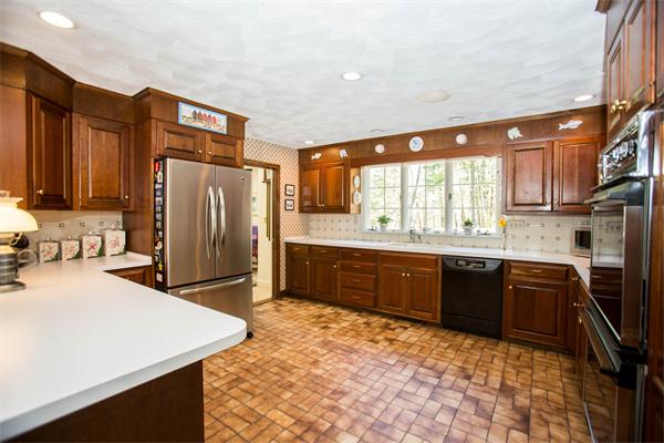 85 Myles Standish Road Weston, MA 02493 - Photo 13 of 28 a large kitchen with stainless steel appliances granite countertop a refrigerator a sink dishwasher a stove top oven and a dining table with wooden floor