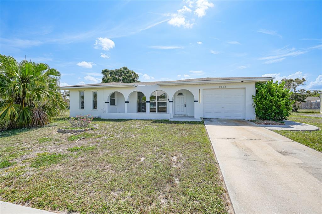 2166 Beacon Drive Port Charlotte, FL 33952 - Photo 1 of 36 a house view with swimming pool and trees in the background