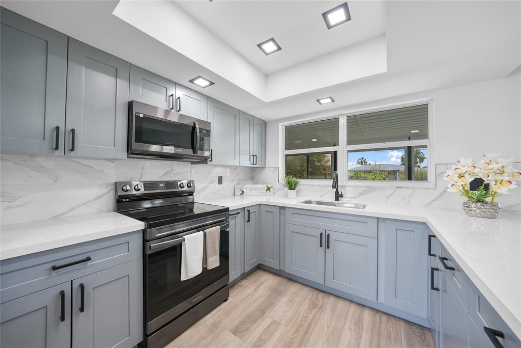 2166 Beacon Drive Port Charlotte, FL 33952 - Photo 11 of 36 a kitchen with a sink stove and microwave