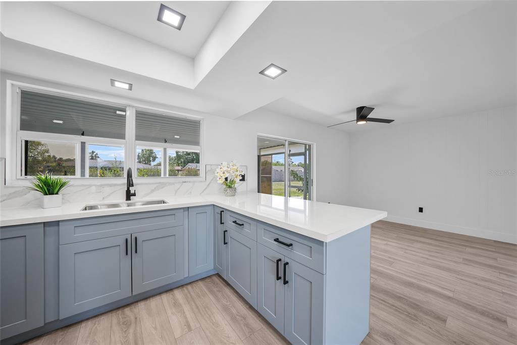 2166 Beacon Drive Port Charlotte, FL 33952 - Photo 12 of 36 a view with double vanity sink a mirror a window and a wooden floor