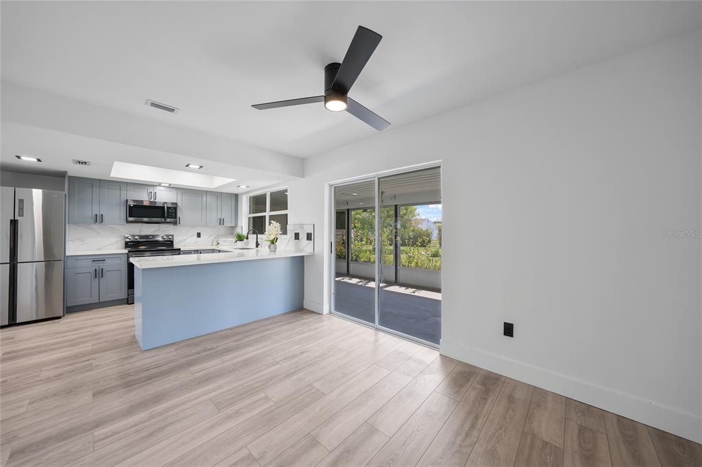2166 Beacon Drive Port Charlotte, FL 33952 - Photo 13 of 36 a large kitchen with stainless steel appliances kitchen island a large counter top and a wooden floors