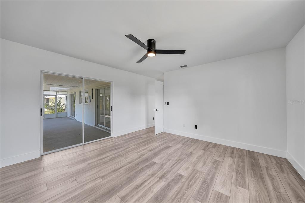 2166 Beacon Drive Port Charlotte, FL 33952 - Photo 14 of 36 a view of empty room with wooden floor and fan