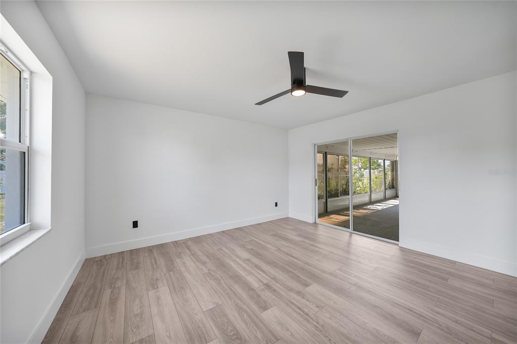 2166 Beacon Drive Port Charlotte, FL 33952 - Photo 15 of 36 a view of empty room with wooden floor and fan