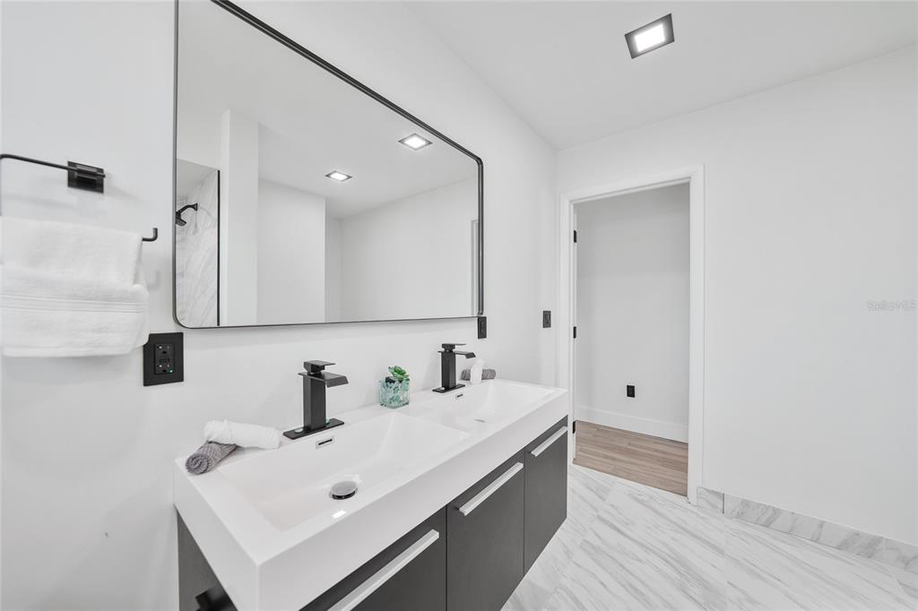 2166 Beacon Drive Port Charlotte, FL 33952 - Photo 19 of 36 a bathroom with a sink a mirror and shower