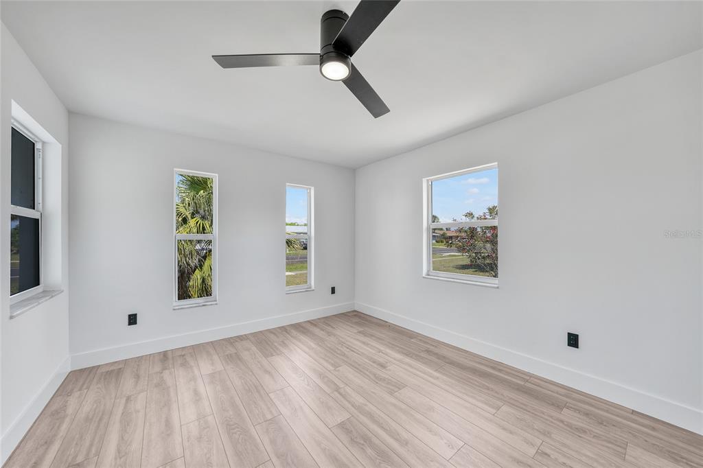 2166 Beacon Drive Port Charlotte, FL 33952 - Photo 20 of 36 wooden floor in an empty room with a window