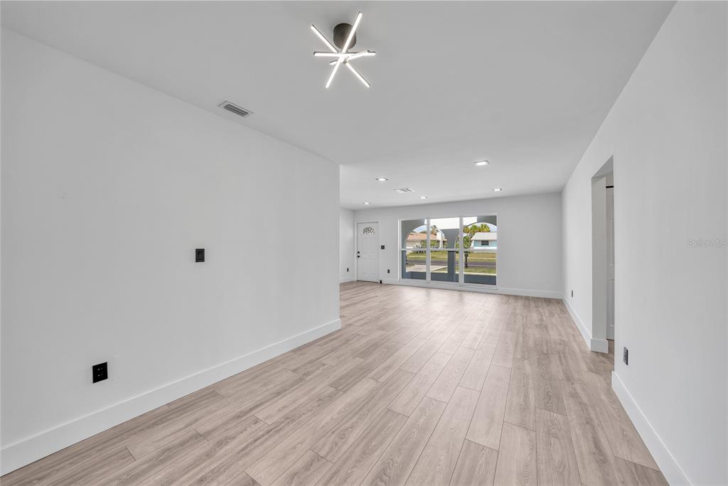 2166 Beacon Drive Port Charlotte, FL 33952 - Photo 5 of 36 wooden floor in an empty room with a window