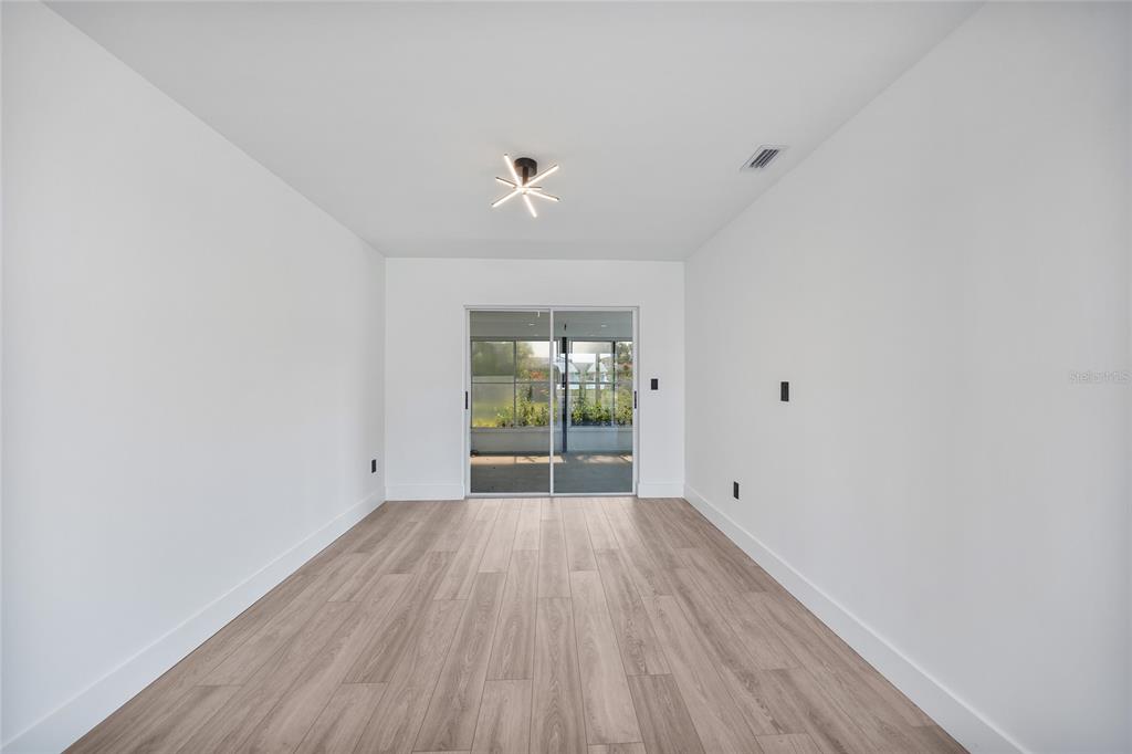 2166 Beacon Drive Port Charlotte, FL 33952 - Photo 6 of 36 wooden floor in an empty room with a window