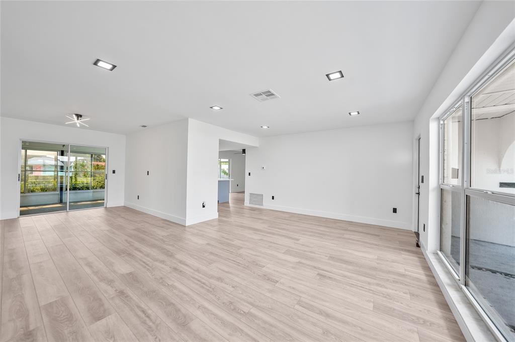 2166 Beacon Drive Port Charlotte, FL 33952 - Photo 7 of 36 a view of an empty room with wooden floor and a window