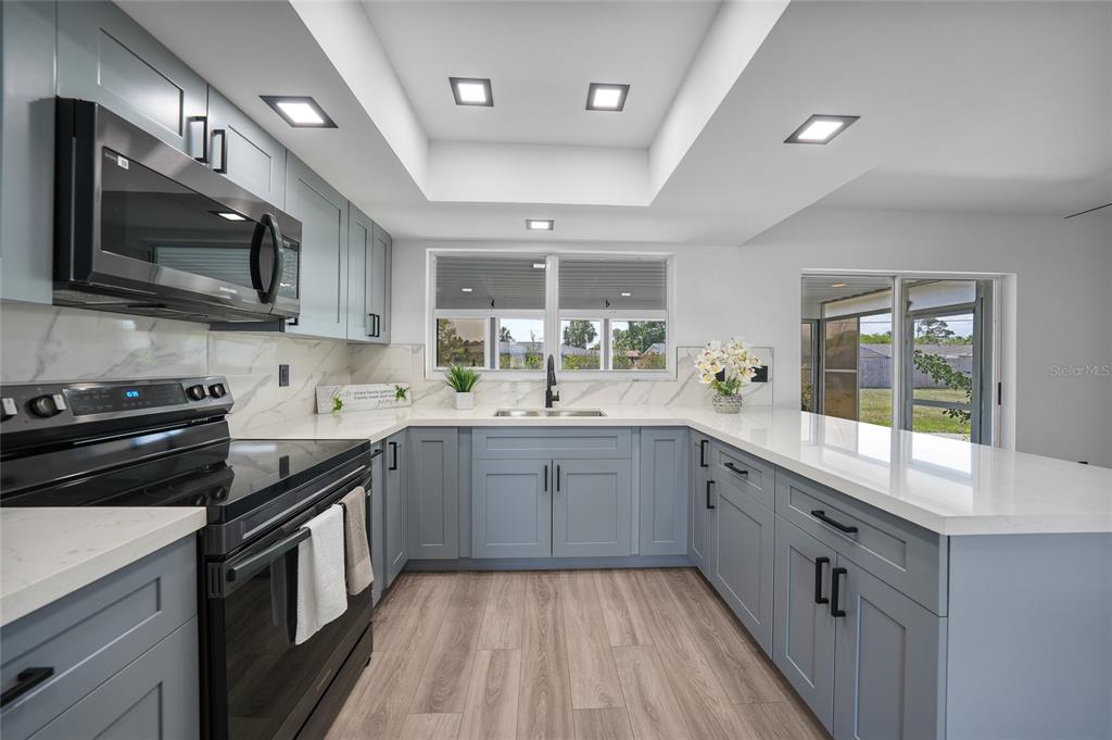2166 Beacon Drive Port Charlotte, FL 33952 - Photo 9 of 36 a kitchen with stainless steel appliances granite countertop a stove and a sink