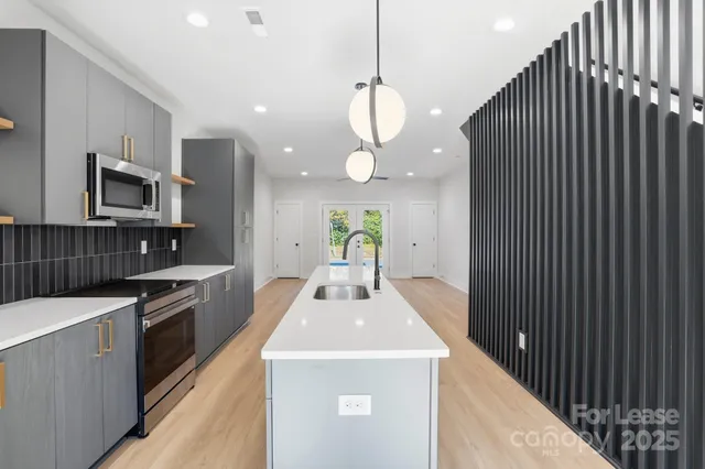 a kitchen with kitchen island a sink stainless steel appliances and cabinets