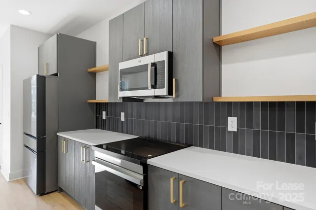a kitchen with stainless steel appliances a microwave a sink and cabinets