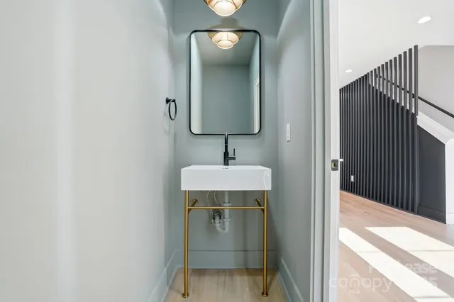 a view of a hallway with wooden floor and a cabinet