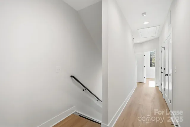 a view of a hallway with a white walls and stairs