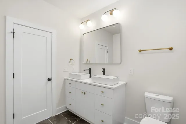 a bathroom with a toilet sink and mirror