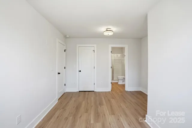 a view of a room with wooden floor and white walls
