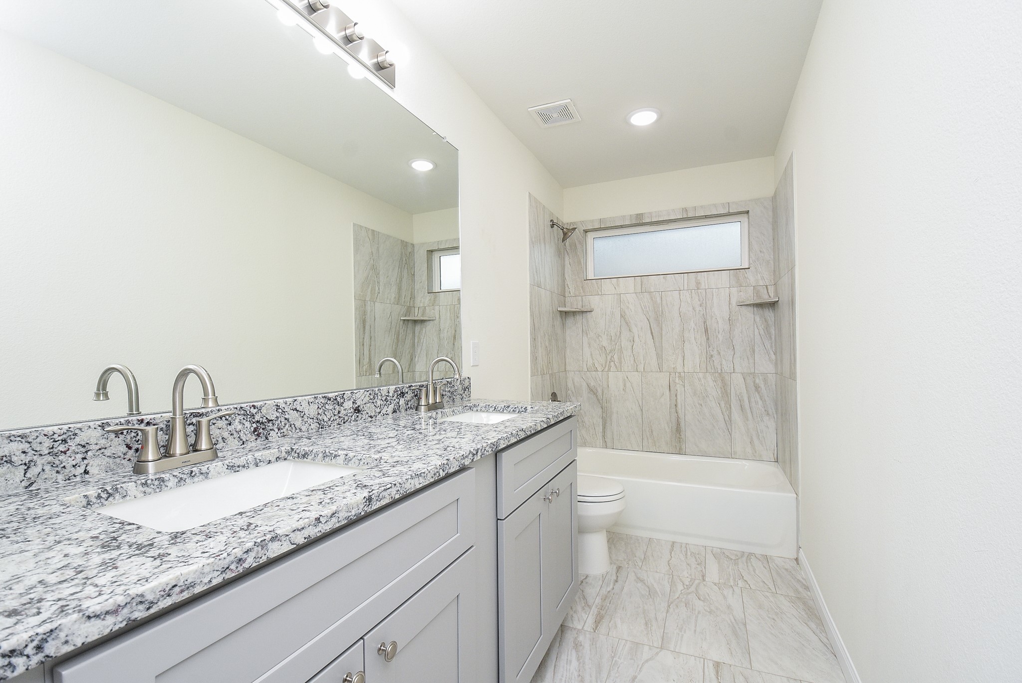 2807 Topiary Lane Houston, TX 77014 - Photo 22 of 32 a bathroom with a granite countertop sink a mirror and a bathtub