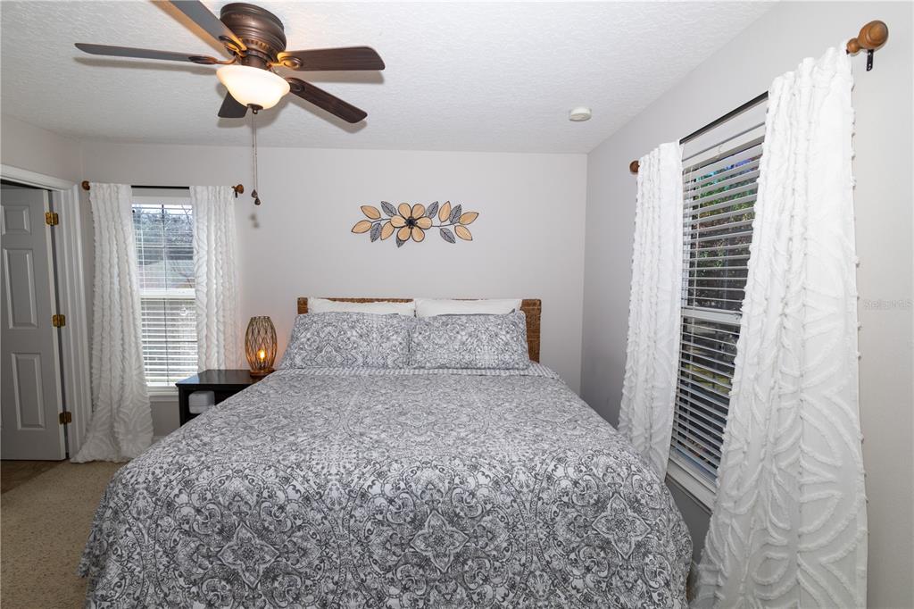 3305 Schoolhouse Road St. Cloud, FL 34773 - Photo 35 of 83 a bedroom with a large bed and a chandelier