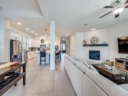 a living room with stainless steel appliances furniture a fireplace and a view