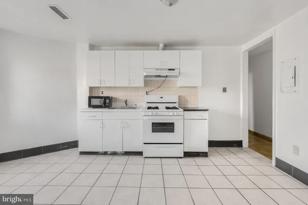 a kitchen with a stove a sink and a refrigerator