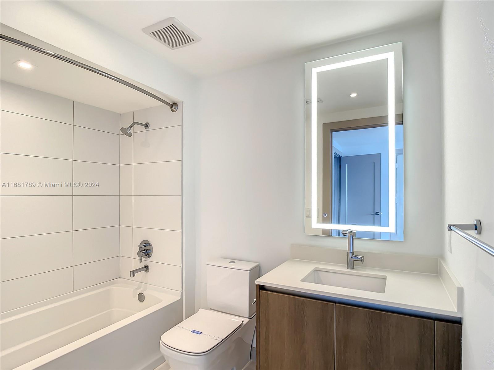 340 Southeast 3rd Street, Unit 1802 Miami, FL 33131 - Photo 19 of 36 a bathroom with a sink a toilet and shower