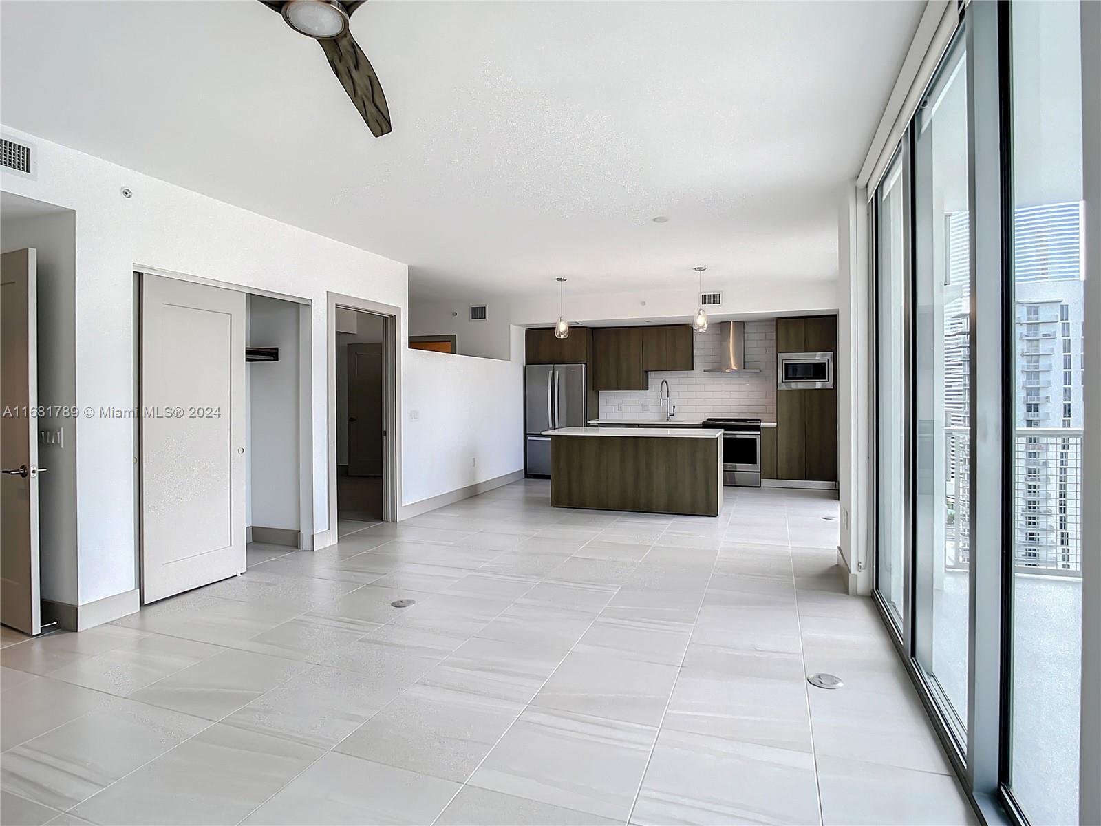 340 Southeast 3rd Street, Unit 1802 Miami, FL 33131 - Photo 7 of 36 a view of a kitchen with a sink and a refrigerator