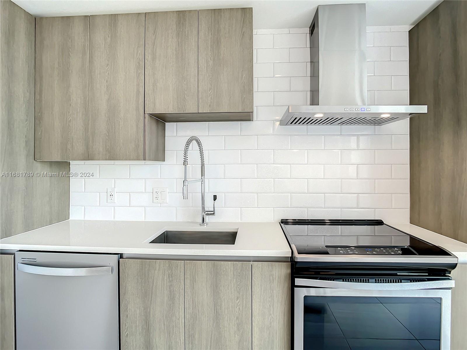 340 Southeast 3rd Street, Unit 1802 Miami, FL 33131 - Photo 10 of 36 a kitchen with granite countertop a sink stove and cabinets