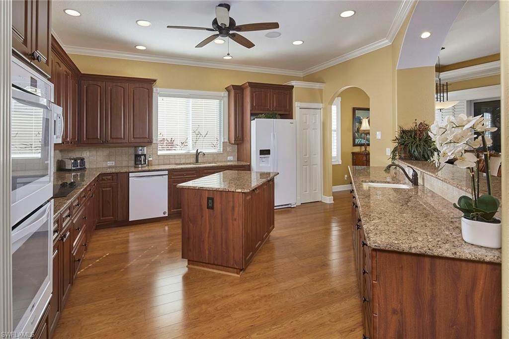 377 Mallory Court Naples, FL 34110 - Photo 8 of 29 a kitchen with stainless steel appliances granite countertop a sink counter space cabinets and a large window