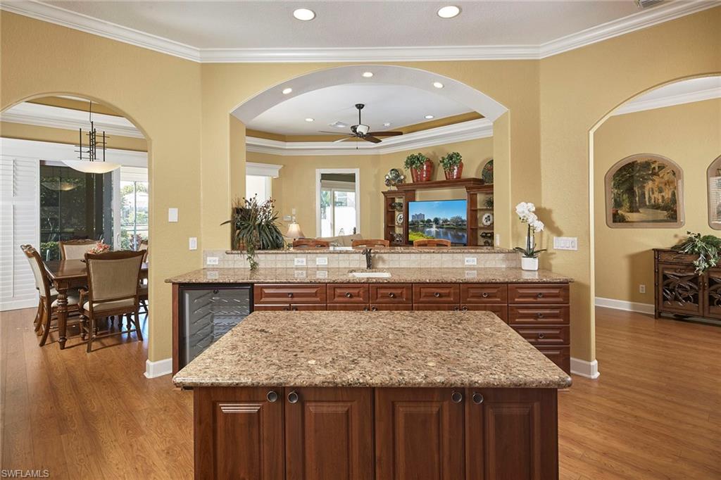 377 Mallory Court Naples, FL 34110 - Photo 10 of 29 a view of living room kitchen with stainless steel appliances granite countertop furniture and fireplace