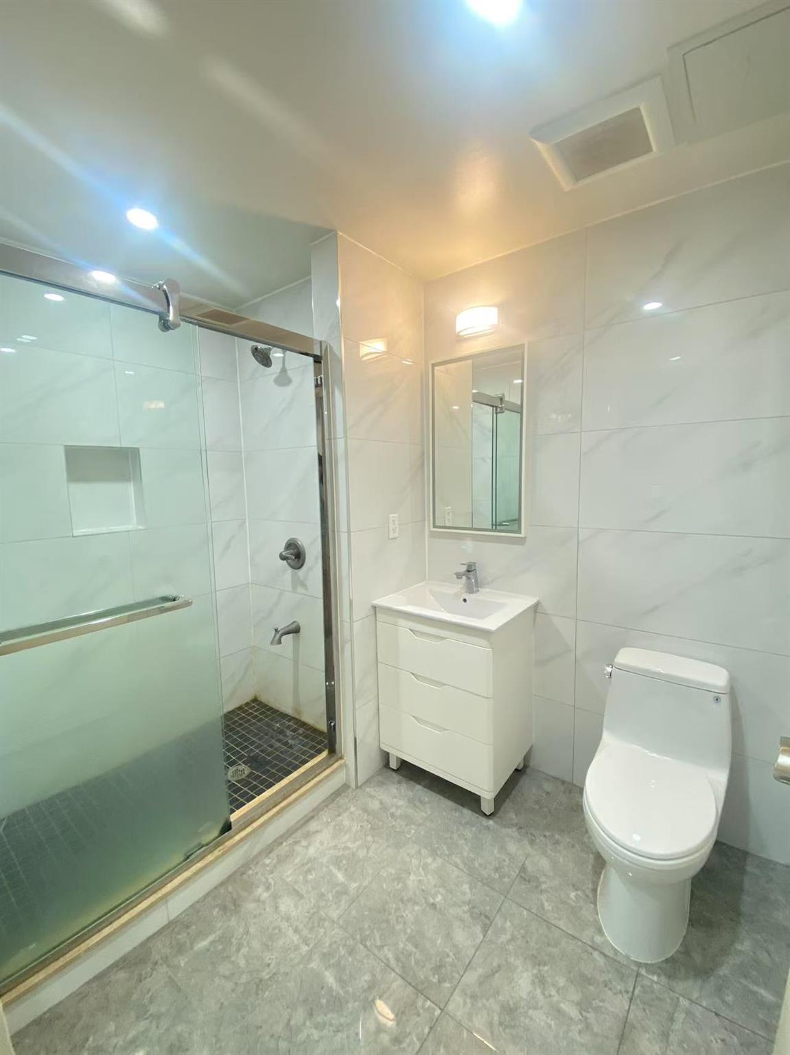 42-22 Crescent Street, Unit 3B Queens, NY 11101 - Photo 5 of 9 a bathroom with a toilet sink and shower