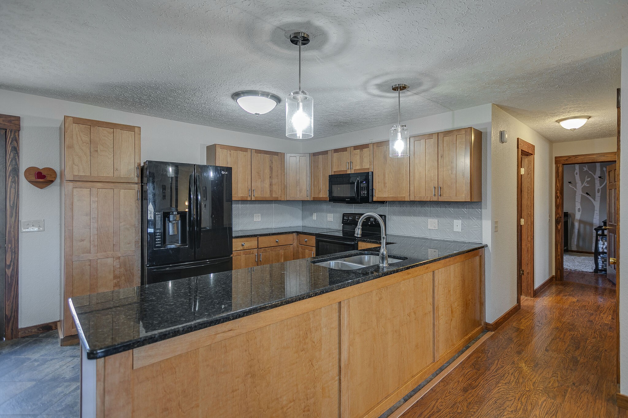 10997 Rials Branch Road Bon Aqua, TN 37025 - Photo 11 of 39 a large kitchen with granite countertop a large counter top appliances and cabinets