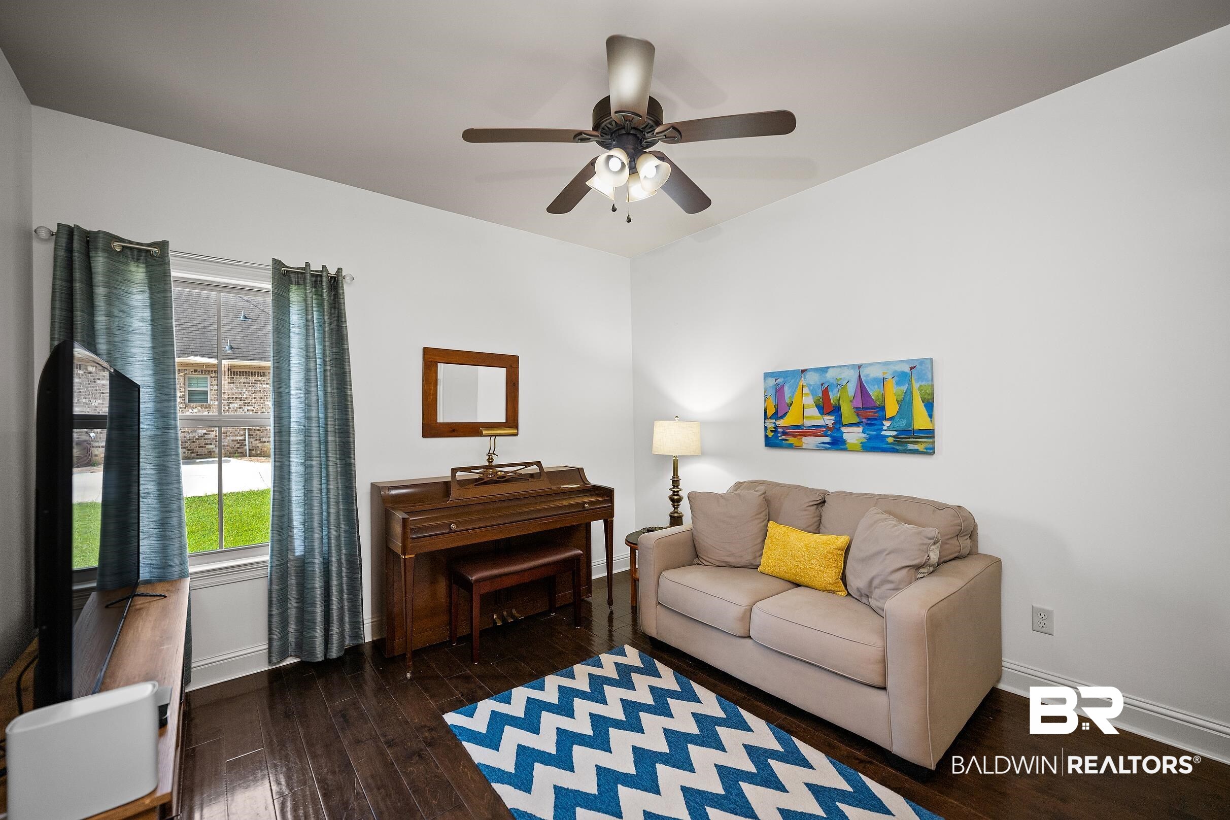 313 Pecan Ridge Boulevard Fairhope, AL 36532 - Photo 22 of 51 Hardwood-finish flooring, a ceiling fan with integrated lighting, and white baseboards define this room