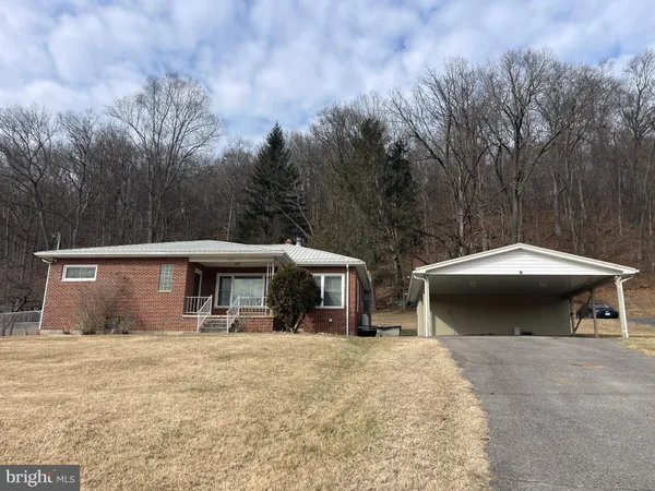 a view of a house with a yard and sitting area