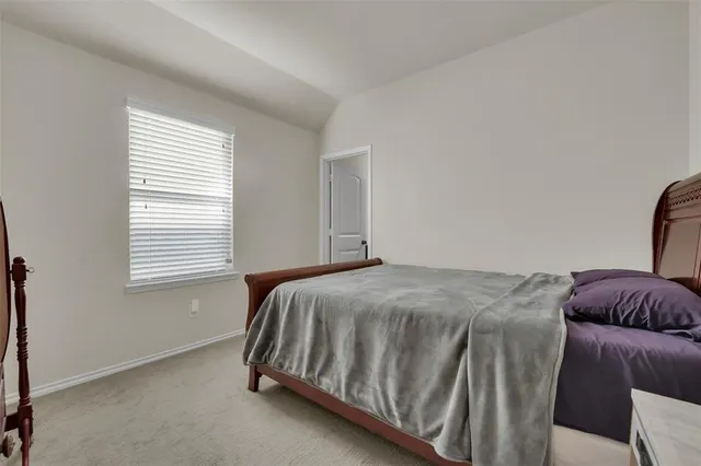 a bed sitting in a bedroom next to a window