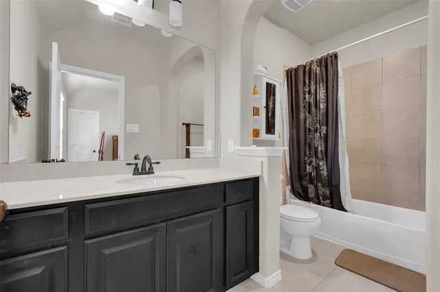 a bathroom with a granite countertop sink toilet a mirror and shower