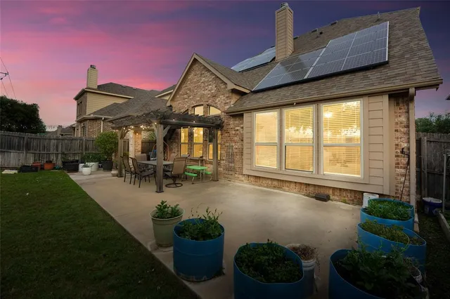 a view of a patio with table and chairs potted plants and a large tree