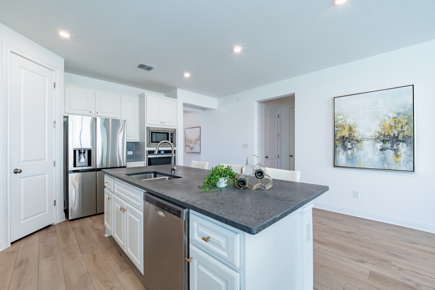 1040 Villa Rialto View Leander, TX 78641 - Photo 13 of 27 Kitchen with white cabinets, stainless steel appliances, light wood finished floors, an island with sink, and recessed lighting