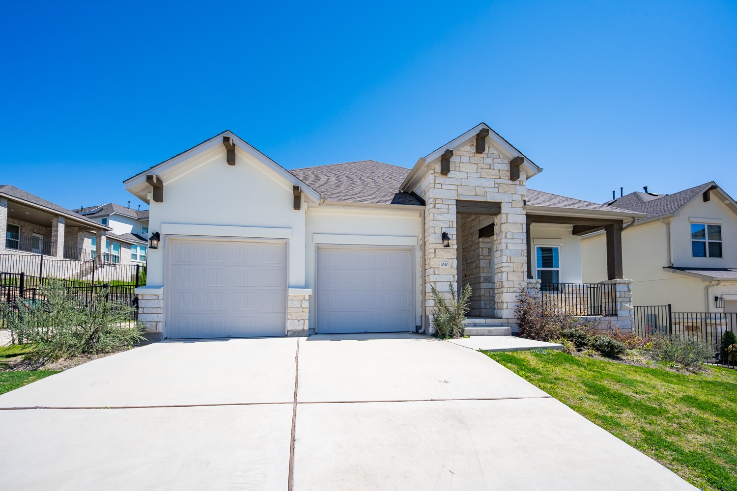 1040 Villa Rialto View Leander, TX 78641 - Photo 27 of 27 View of front of property featuring stone siding, an attached garage, driveway, a shingled roof, and stucco siding