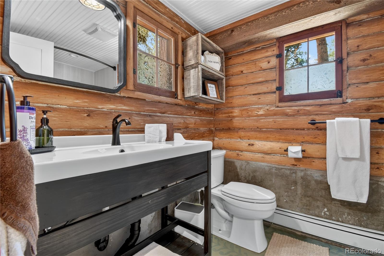 23301 Shoshone Road Indian Hills, CO 80454 - Photo 13 of 32 a bathroom with a sink a toilet and mirror